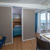 Interno di un bungalow con camera da letto e vista mare.