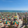 Spiaggia con molti ombrelloni colorati.