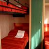 Letti a castello con coperte rosse in una stanza compatta.