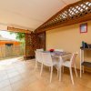 Veranda con tavolo e sedie bianche.