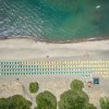 Spiaggia con ombrelloni colorati allineati lungo la sabbia vicino al mare.