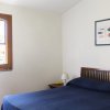 Camera da letto con letto matrimoniale blu e un quadro di pesci sul muro.