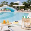 Piscina con sedie a sdraio e un ponte azzurro.