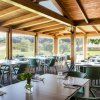 Sala da pranzo con tavoli apparecchiati e vista sul giardino.