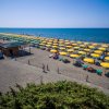 Spiaggia con file di ombrelloni gialli vicino al mare.