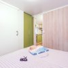 Camera con letto, occhiali da sole e borsa colorata.