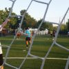 Calciatori su campo sintetico, visto dalla porta.