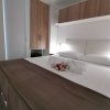 Letto matrimoniale con coperte marroni, decorato con fiori e asciugamani.