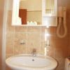 Lavabo da bagno con specchio, asciugacapelli e dispenser.