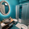 Bagno moderno con pareti turchesi e doccia a vetri.
